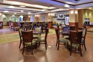 哈里森哈里森希尔顿恒庭酒店的一间带桌椅的餐厅和一间酒吧