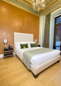 昆卡Itza Hotel Boutique Internacional的卧室配有一张带吊灯的大型白色床。