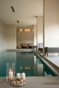 卡瓦拉艾格纳提亚城市Spa酒店的一个带蜡烛的游泳池和一个带蜡烛的桌子