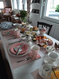 萨尔路易斯Saarlouis, Ortsteil Beaumarais "Anna's Cottage"Bed&Breakfast "#TravellerAwards 2022"的桌上放有盘子和碗的食物