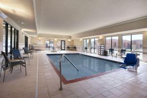 威利斯顿威利斯顿汉普顿酒店及套房的一座带椅子的酒店游泳池
