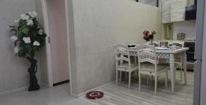 杜尚别Квартира с хорошей энергетикой的厨房配有白色的桌椅和花瓶