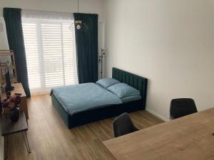 尼特拉Moderný apartmán A408 v centre NR, parkovanie v cene的一间卧室配有一张床、一张桌子和一个窗户。