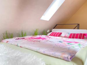 布吕尔Apartment am Schloss的一间卧室配有带粉色床单和粉红色枕头的床。