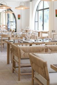 曼讷Le Couvent des Minimes Hôtel & Spa L'Occitane的用餐室设有桌椅和窗户。