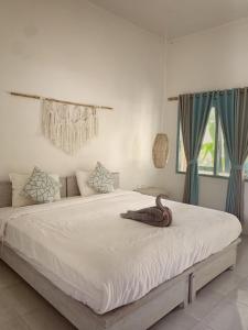 SekongkangKacchapa Beach Resort and Restaurant的卧室配有一张带蓝色窗帘的大型白色床