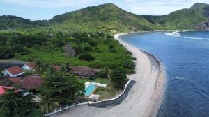 SekongkangKacchapa Beach Resort and Restaurant的享有海滩的空中景致,设有房屋和海洋