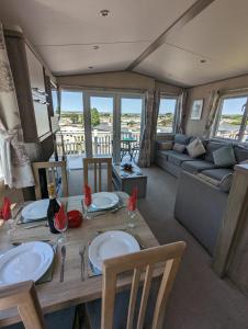 韦茅斯Littlesea Caravan on a Fabulous elevated position Haven Weymouth的客厅配有桌子和沙发