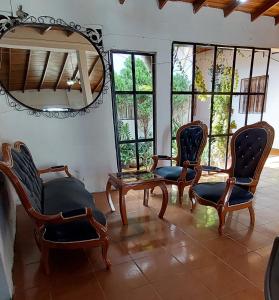 San Antonio del TáchiraHOTEL CASA COLONIAL的配有椅子、镜子和窗户的房间