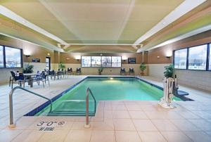 伯洛伊特汉普顿伯洛伊特酒店的大楼内一个带桌椅的游泳池