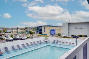 大洋城火烈鸟汽车旅馆的一个带椅子的游泳池以及停车场