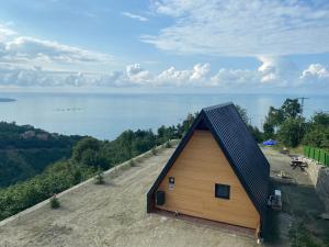 特拉布宗Private Bungalow的水边小山上的小屋,有黑色屋顶