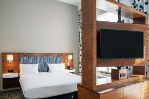 谢尔曼·奥克斯谢尔曼奥克斯希尔顿恒庭旅馆&套房酒店的配有一张床和一台平面电视的酒店客房
