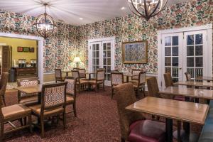 列克星敦Hampton Inn Lexington Historic Area的餐厅配有桌椅和花卉壁纸