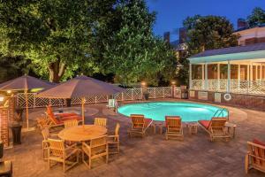列克星敦Hampton Inn Lexington Historic Area的游泳池配有椅子、桌子和遮阳伞