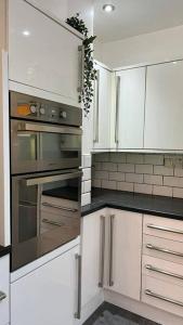 WincobankStylish home close to Arena的厨房配有白色橱柜和不锈钢用具