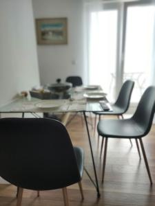 斯普利特Apartment Tina的一间设有玻璃桌和椅子的用餐室