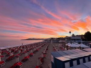 萨沃纳Due passi dal mare的日落时分带椅子和遮阳伞的海滩
