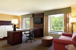 普拉特维尔普拉特维尔汉普顿套房酒店的酒店客房配有1张床、1张书桌、1张床和1张沙发。