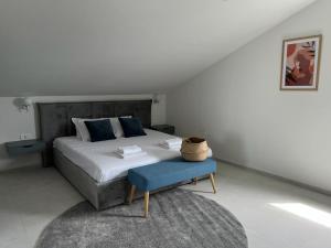扎顿Vitas Apartments的一间卧室配有一张大床和蓝色凳子