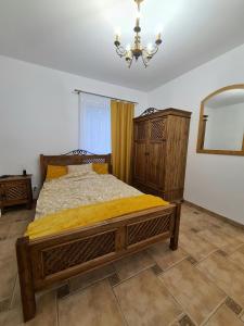 PołęczynoAgroturystyka Galant的一间卧室配有一张床、镜子和吊灯
