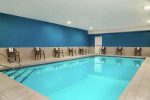 蓝溪市堪萨斯城蓝泉希尔顿恒庭酒店的游泳池,酒店客房带椅子
