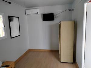马拉加Finca los nogales的一间设有冰箱和墙上电视的客房