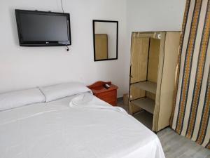 马拉加Finca los nogales的卧室配有一张床,墙上配有电视。