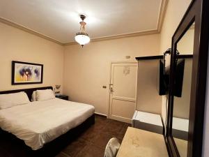 马达巴莎乐美酒店的一间卧室配有一张床和一台电视。