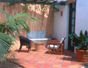 圣米格尔德阿沃纳卡萨圣米格尔酒店的庭院配有两把椅子、一张桌子和一张长凳