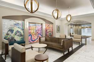 新奥尔良法国区中心汉普顿酒店的大堂配有沙发、桌子和绘画作品