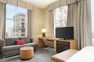 新奥尔良法国区中心汉普顿酒店的酒店客房配有床、沙发和电视。