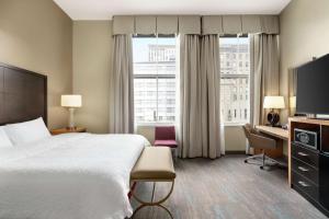新奥尔良法国区中心汉普顿酒店的配有一张床、一张书桌和一扇窗户的酒店客房