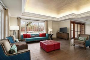 新奥尔良新奥尔良/圣查尔斯大道汉普顿酒店的客厅配有沙发、椅子和电视