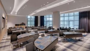 奥伯丁希尔顿慕尼黑机场酒店的一间会议室,配有桌椅和窗户