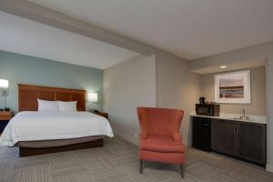 默特尔比奇哈伯盖特汉普顿酒店的配有一张床和一把椅子的酒店客房
