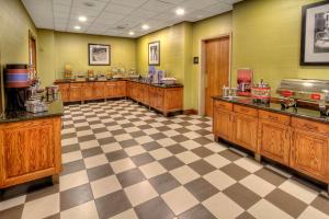 楠帕爱达荷中心南帕套房汉普顿酒店的厨房设有木制橱柜和 ⁇ 格地板。