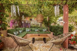 扎金索斯镇Filoxenia Luxury Studios & Apartments的一个带绿色沙发和两把椅子的花园