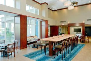 大洋城海洋城汉普顿套房酒店 的大型用餐室配有大桌子和椅子