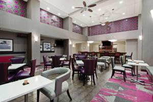 阿拉米达奥克兰机场阿拉米达希尔顿恒庭旅馆&套房酒店的一间带桌椅的餐厅和一间酒吧