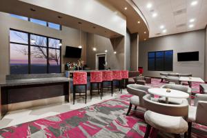 阿拉米达奥克兰机场阿拉米达希尔顿恒庭旅馆&套房酒店的大堂设有带桌椅的酒吧