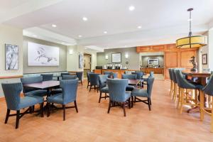 沃思湖沃思湖 - 收费公路 - 西棕榈滩汉普顿酒店的一间设有蓝色桌椅的餐厅和一间厨房