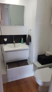 PoignyAncien corps de ferme的浴室配有白色水槽和卫生间。