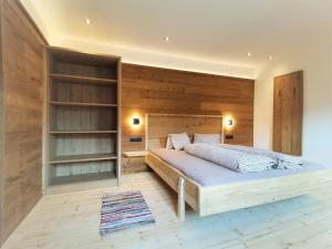 菲根贝格Ferienwohnung-1-Gilfert的一间卧室设有一张床和木墙