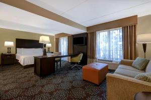 微风湾彭萨科拉/微风湾汉普顿酒店及套房的配有一张床和一张书桌的酒店客房