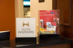 雷纳姆雷纳姆陶顿汉普顿酒店的耳道荣誉的标志和柜台上的一盒食物
