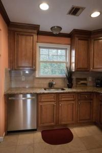 伊丽莎白Family 3-bedroom home (2nd floor near EWR/Outlet)的厨房配有木制橱柜、水槽和窗户。