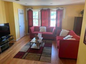 伊丽莎白Family 3-bedroom home (2nd floor near EWR/Outlet)的客厅配有2张红色沙发和1张咖啡桌