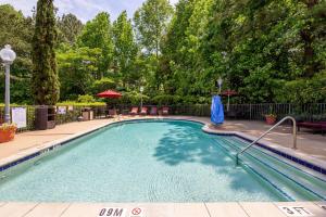 卡瑞Hampton Inn & Suites Raleigh/Cary I-40 (PNC Arena)的一座树木繁茂的庭院内的游泳池