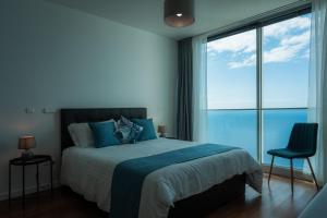 蓬他达维托亚Sea View Villa Mar Lindo nr Ponta do Sol的一间卧室设有一张床,享有海景